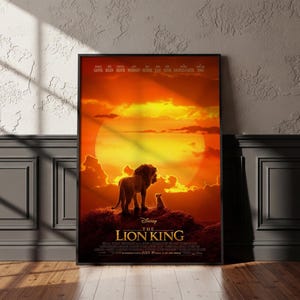 Op de afbeelding: Een ingelijste filmposter van The Lion King met een grote leeuw en een kleine welp op een rotsachtige klif tegen een levendige oranje en gele zonsondergang. De tekst bevat de titel The Lion King en een lijst met castleden bovenaan.