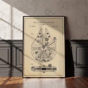 May include: A framed wall art print featuring a technical patent illustration of the Millennium Falcon. The design includes black line drawings on a beige background with the text Millennium Falcon, No. 228,688, and Apr 19, 1979, showing top and side views.