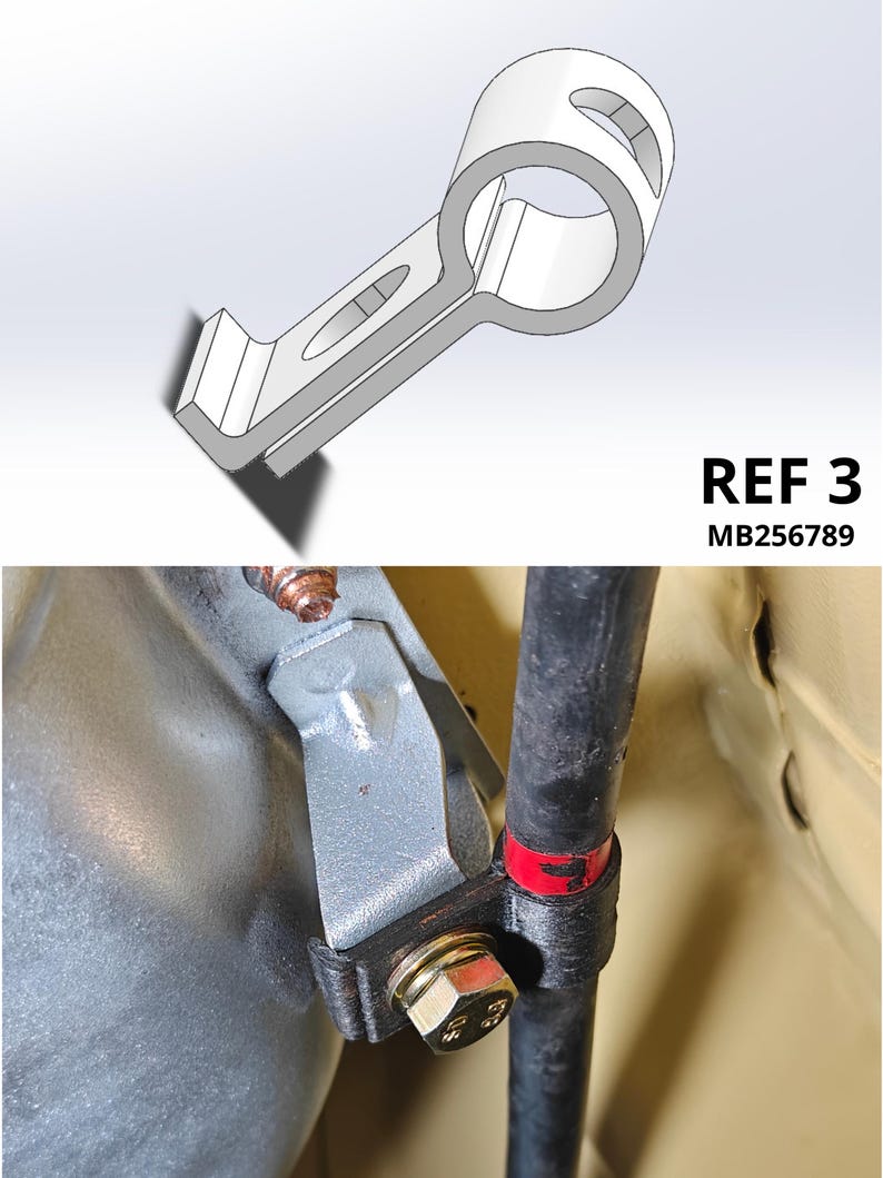 May include: A gray metal mounting bracket with a circular opening and an elongated slot, labeled REF 3 MB256789. The bracket is shown in a technical diagram and installed on a vehicle component, securing a black pipe with a bolt and a red marker.