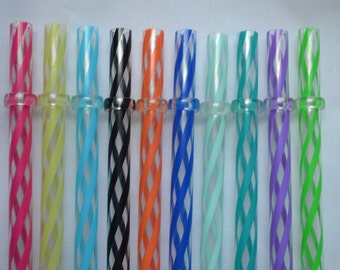May include: A collection of colorful, reusable drinking straws. Each straw features a clear base with a spiral design in various colors, including pink, yellow, blue, black, orange, and green. A clear ring connects each straw.