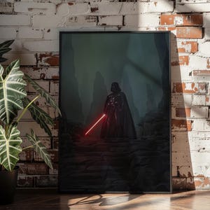 Könnte beinhalten: Ein rechteckiger gerahmter Wandkunstdruck mit einer dunklen, atmosphärischen Szene einer schwarz gepanzerten Figur mit Umhang auf einem felsigen Pfad. Die Figur hält ein leuchtendes rotes Lichtschwert, das ein helles karmesinrotes Licht wirft.