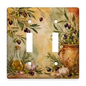 May include: A double light switch plate featuring a painted scene of olive branches, a glass cruet filled with golden oil, and garlic bulbs. The background has a textured, mottled appearance in shades of beige, yellow, and green.