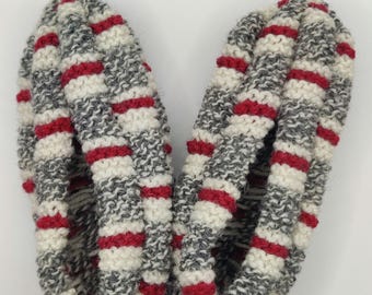 May include: A pair of gray and white knitted slippers with red stripes. The slippers are made of a soft, cozy material and have a comfortable fit.