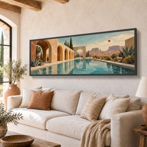 Puede incluir: Una impresión artística panorámica enmarcada que muestra un paisaje desértico con una piscina larga, una serie de arcos de piedra beige, cipreses altos y mesetas distantes bajo un cielo azul pálido con un pequeño sol naranja arriba a la derecha.