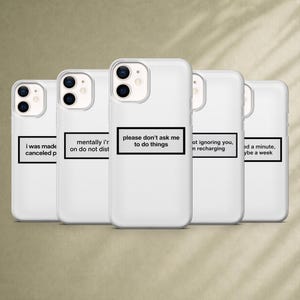 May include: Five white smartphone cases arranged in a row, each featuring a black rectangular border containing unique text. The center case displays the phrase, please don't ask me to do things, while the others show various humorous social messages.