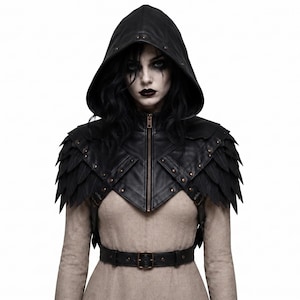 May include: A black hooded shrug featuring a front zipper closure, layered feather-like shoulder panels, and metallic stud accents. The garment includes a matching black belt with a buckle, worn over a plain beige long-sleeved top.