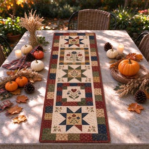 Pode incluir: Um caminho de mesa acolchoado retangular com um design de patchwork com blocos alternados de padrões de estrelas e motivos florais em tons de azul-marinho, vermelho profundo, verde-oliva e creme, exibido numa mesa de pedra com abóboras.