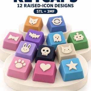 May include: A collection of 12 colorful keycaps featuring raised icons including a fox, bat, ghost, robot, rabbit, skull, cat, paw print, heart, and star. The text reads KEYCAPS 12 RAISED-ICON DESIGNS STL + 3MF and 3 FIT-TEST CAPS INCLUDED.
