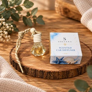 May include: A clear diamond-shaped glass car diffuser bottle with a light wooden cap and a braided cord, accompanied by a white rectangular box labelled SOELENA SCENTED CAR DIFFUSER 8 ml, featuring a blue starfish and seashell graphic design.