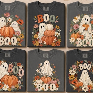 Op de afbeelding: Zes antracietgrijze T-shirts met diverse Halloween-thema prints. Elk shirt toont illustraties van spoken, pompoenen en herfstbloemen, waarbij het woord BOO in verschillende lettertypes en kleuren in de ontwerpen is verwerkt.