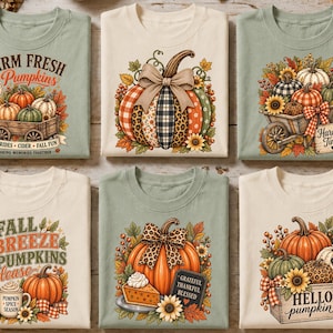 Peut inclure: Une collection de six t-shirts vert sauge et crème, chacun arborant des imprimés graphiques sur le thème de l'automne avec des citrouilles, des tournesols et des feuilles. Les motifs incluent des textes comme Farm Fresh Pumpkins et Hello Pumpkin.