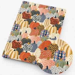 May include: A rectangular fabric piece featuring a repeating pattern of pumpkins in various colors including orange, blue, pink, and cream. The pumpkins are decorated with diverse textures such as leopard spots, polka dots, and geometric diamond shapes.