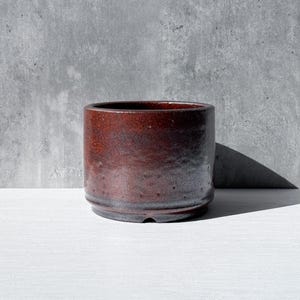 May include: A white ceramic mug with a black handle and the text "But First, Coffee" in a black, bold font. The mug is on a white surface. The mug is 4 inches tall.