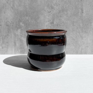 May include: A set of three ceramic mugs with a speckled, matte finish. The mugs are in shades of cream, light gray, and dark gray. Each mug has a simple, minimalist design, perfect for coffee or tea.