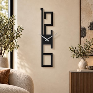 Puede incluir: Un reloj de pared vertical con un marco negro y números 1, 2, 3 y 6 estilizados y calados, dispuestos en una columna lineal. El reloj tiene dos manecillas de metal plateado delgadas situadas en el centro para indicar la hora.