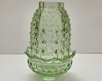 May include: A light green glass lamp shade featuring a hobnail pattern with raised circular bumps. The shade has a cylindrical upper section and a wider, scalloped base with a matching textured hobnail design throughout the glass surface.