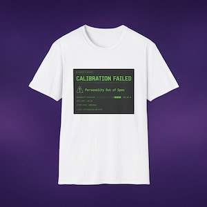 Peut inclure: Un t-shirt blanc à manches courtes avec un graphique rectangulaire gris foncé sur la poitrine. Le graphique affiche du texte vert indiquant CALIBRATION FAILED et Personality Out of Spec, avec une icône d'avertissement et des données système.