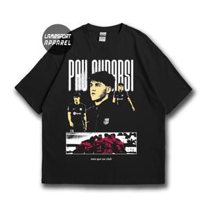 Könnte beinhalten: Ein schwarzes Kurzarm-T-Shirt mit einem Grafikdruck des Fußballers Pau Cubarsi. Das Design enthält den Text "PAU CUBARSI" oben, "LAMBSPORT APPAREL" in einem Kreis und "mes que un club" unten mit einem Bild einer jubelnden Mannschaft.