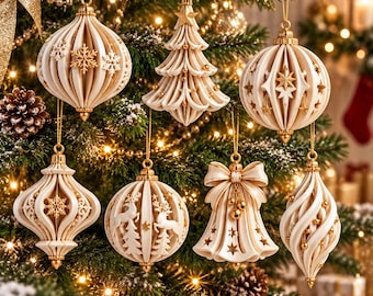 May include: A collection of seven cream-colored Christmas ornaments with intricate cut-out designs, including a tree, a bell with a bow, and various spherical and teardrop shapes, all featuring gold-toned accents and hanging from thin gold strings.