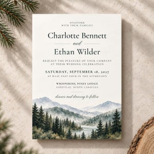 May include: A rectangular wedding invitation card featuring black serif and script text on a white background. The text reads: Together with their families, Charlotte Bennett and Ethan Wilder, request the pleasure of your company at their wedding celebration, Saturday, September 18, 2027, at half past four in the afternoon, Whispering Pines Lodge, Asheville, North Carolina, dinner and dancing to follow. The bottom portion displays a watercolor illustration of a misty mountain range with evergreen trees and a river.