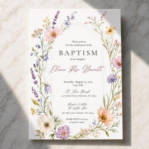 Peut inclure: Une carte d'invitation de baptême blanche avec une bordure florale aquarelle composée de fleurs sauvages roses, violettes, jaunes et bleues. Le texte indique : Please join us for the celebration of the BAPTISM of our daughter Eliana Rose Bennett, Saturday, August 23, 2025, 11:30 AM, St. Anne Parish, 214 Garden Street, Charlotte, NC 28202, Reception to follow The Willow Room, 38 Cedar Lane, Charlotte, NC 28204, Kindly RSVP to Grace at 555-812-4076.
