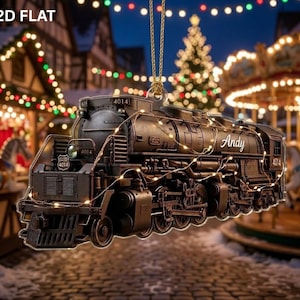 May include: A flat, two-dimensional hanging ornament shaped like a black steam locomotive train. The train features the number 4014 on the front and side, with the name Andy written in white script on the side. It is wrapped in thin fairy lights.