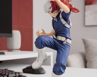 May include: A Shoto Todoroki anime character figurine featuring split white and red hair, a blue tactical suit, white boots, and a translucent red flame effect extending from the left arm. The figure is posed in a dynamic action stance.