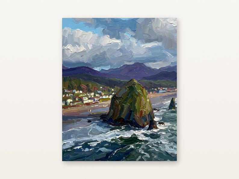 May include: An oil painting of a coastal landscape featuring a large, dark green rock formation rising from the ocean. The scene includes a sandy beach, a small town with houses, distant purple mountains, and a cloudy blue sky above the sea.