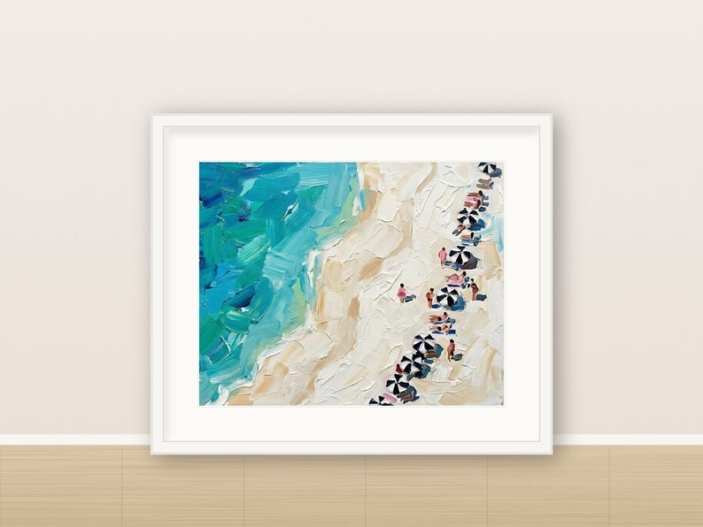 May include: An oil painting in a white frame depicting an aerial view of a beach with thick, textured brushstrokes. The scene features vibrant turquoise and blue ocean waves meeting a sandy beige shore with small black and white umbrellas.