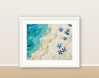 May include: An oil painting in a white frame depicting an aerial view of a beach with thick, textured brushstrokes. The scene features vibrant turquoise and blue ocean waves meeting a sandy beige shore dotted with small, blue and white striped umbrellas.