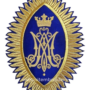May include: An oval-shaped embroidered patch featuring a deep blue center with a gold-stitched crown and an ornate monogram. The design is surrounded by a radiant gold sunburst border with pointed rays. The text "exquisitembroidery" is visible.