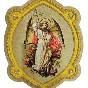 Può includere: Una targa da parete a forma di scudo con un'illustrazione centrale di un angelo alato che tiene un bastone sormontato da una croce mentre sta sopra un drago a più teste. Il bordo è dorato con tessuto testurizzato, frange gialle e quattro cristalli.