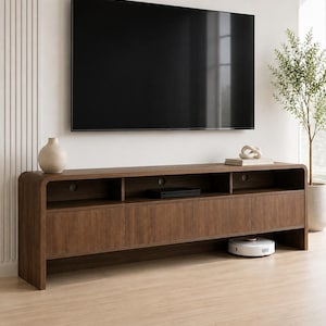 May include: A long, dark wood media console featuring rounded edges, four cabinet doors, and three open storage compartments with circular cable management holes. A large flat-screen television is mounted on the wall above the console.