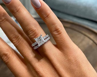 Anillo de compromiso solitario con talla princesa y piedra de acento, con alianza a juego en plata de ley 925. Regalo ideal para pedidas de mano o cumpleaños.