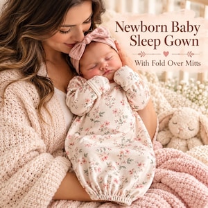 May include: A newborn baby sleep gown featuring a light cream base with a delicate pink floral pattern, long sleeves with fold-over mitts, and a matching pink knotted headband. The text reads Newborn Baby Sleep Gown With Fold Over Mitts.