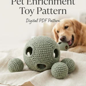 May include: A sage green crocheted pet enrichment toy set consisting of one large hollow sphere with circular openings and three smaller solid spheres. The text Pet Enrichment Toy Pattern Digital PDF Pattern is displayed above the items.