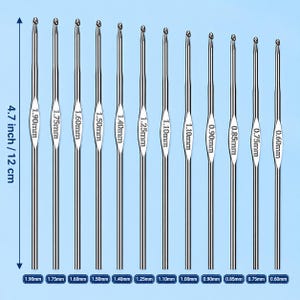 May include: A set of twelve silver-colored metal crochet hooks arranged vertically. Each hook features a specific size printed on the shaft, ranging from 0.60mm to 1.90mm. A vertical measurement indicator shows a total length of 4.7 inches or 12 cm.