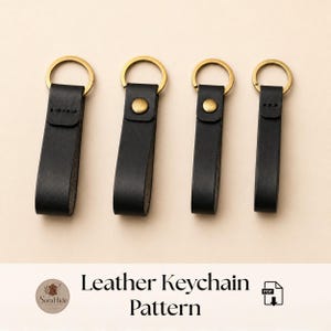 Puede incluir: Cuatro llaveros de cuero negro de diferentes longitudes dispuestos en fila. Cada llavero cuenta con una anilla de metal dorado en la parte superior. Dos de los llaveros están asegurados con un remache de metal dorado y dos tienen costuras.