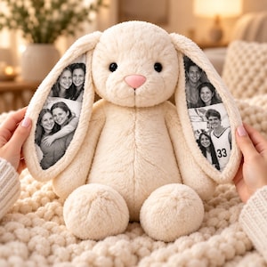 Peut inclure: Un lapin en peluche de couleur crème avec de longues oreilles tombantes. L'intérieur de chaque oreille présente des photographies en noir et blanc de personnes. Le lapin a une texture douce et duveteuse, de petits yeux noirs et un petit nez rose clair.