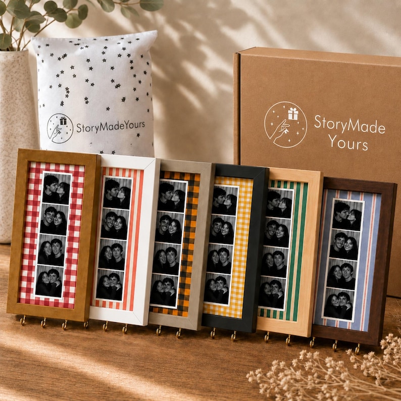 May include: Six rectangular wooden photo frames with metal hooks at the bottom, each displaying a vertical strip of three black and white photos. The frames feature various colored patterns including red gingham, orange stripes, yellow plaid, and blue stripes.