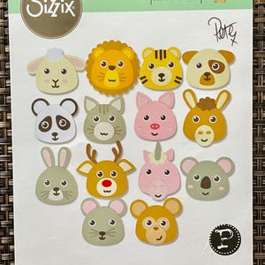 May include: A Sizzix Thinlits die set featuring 20 metal cutting dies for creating various animal faces including a lion, panda, pig, rabbit, deer, unicorn, and koala. The packaging displays the colorful animal designs and the product number 665817.