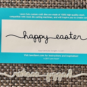 May include: A die-cut craft set with the words "happy easter" in a cursive font. The set includes a die-cut of the same words. The approximate length is 5 3/4 inches. The packaging is teal and white.
