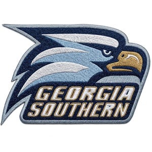 Può includere: Una toppa ricamata raffigurante la mascotte aquila della Georgia Southern in fili blu navy, azzurro e oro. Il design include il testo GEORGIA SOUTHERN in lettere maiuscole bianche con un bordo dorato, su uno sfondo blu navy scuro.