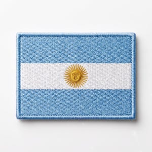 Könnte beinhalten: Ein rechteckiger gestickter Aufnäher mit der Flagge Argentiniens. Das Design besteht aus drei horizontalen Streifen in Hellblau, Weiß und Hellblau, mit einer goldgelben Sonne mit menschlichem Gesicht in der Mitte des weißen Streifens.