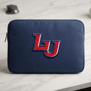 May include: A navy blue rectangular laptop sleeve featuring a centered embroidered logo with the letters LU in red, outlined in white and navy blue. The sleeve has a dark zipper closure along the top edge and a textured fabric exterior finish.
