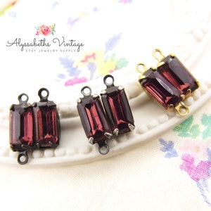 Peut inclure: Trois paires de connecteurs en verre violet pour la fabrication de bijoux. Chaque connecteur a deux boucles et est fait de métal avec une finition dorée, noire ou argentée.