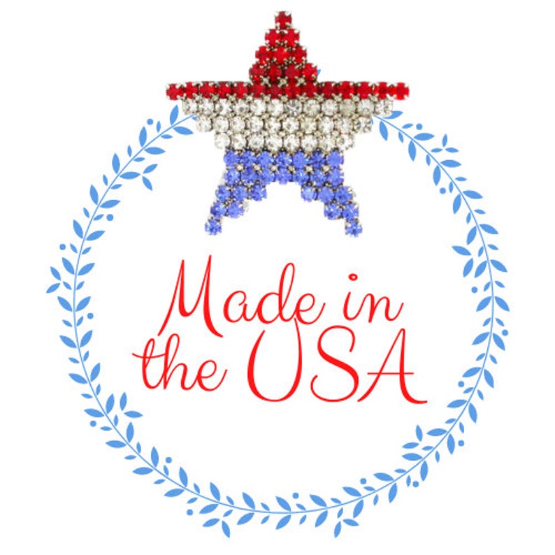 May include: A red, white, and blue star-shaped pin with rhinestones. The star is surrounded by a blue wreath with leaves. The text "Made in the USA" is written in red cursive lettering.