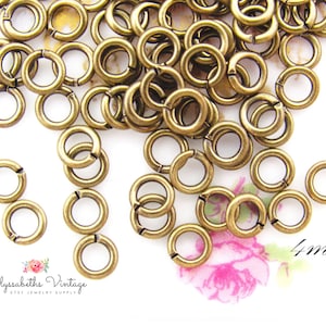 May include: A large quantity of 4 mm antique brass jump rings. The jump rings are small, round, and have a gap for connecting to other jewelry components.