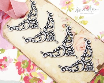 May include: Four silver-toned metal corner embellishments with a decorative floral design.  The embellishments are arranged in a row on a brown paper tag with the text "Alyssabeth's Vintage ETSY Jewelry Supply".