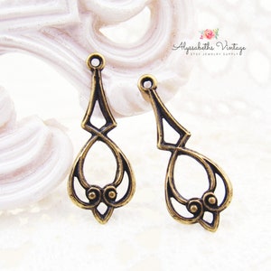 May include: Two antique gold-toned metal earring findings with a decorative, openwork design. The findings have a teardrop shape with a loop at the top for attaching a hook or other jewelry component.